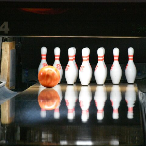 une boule de bowling va frapper les quilles