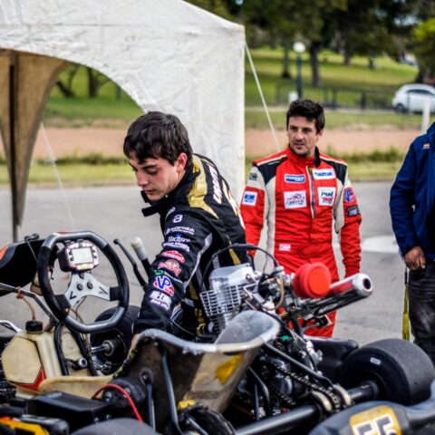 Une équipe prépare un kart pour une course en plein air, mettant en valeur le travail d'équipe et la passion du sport automobile.